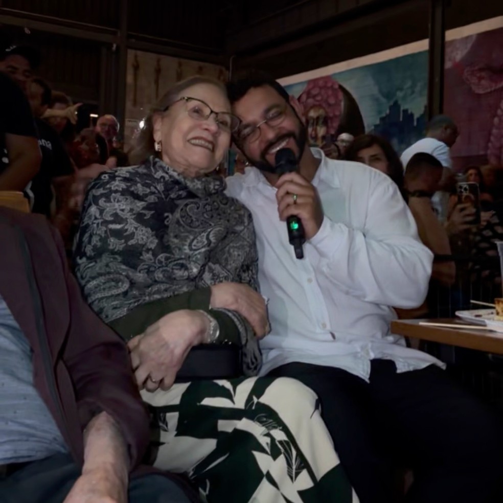 Maria do Carmo, mãe de Renato Russo, com Nilson Junior na plateia do show "Meu irmão Renato Russo" — Foto: @meuirmaorenatorusso
