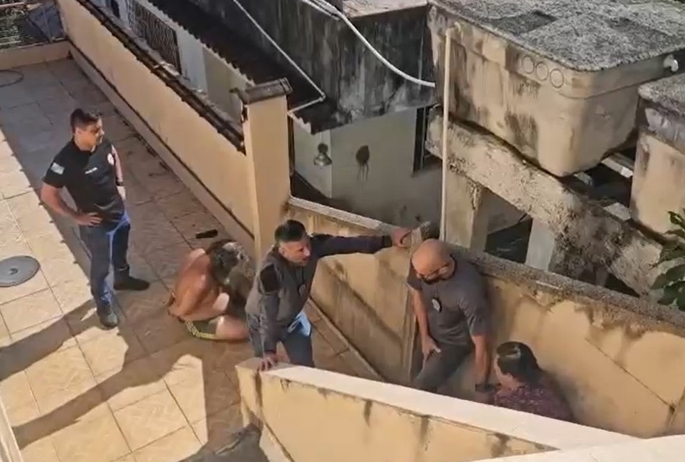 Agentes da 37&ordf; DP (Ilha do Governador) prendem os dois filhos que mantinham o corpo do pai em casa h&aacute; pelo menos seis meses &mdash; Foto: Reprodu&ccedil;&atilde;o