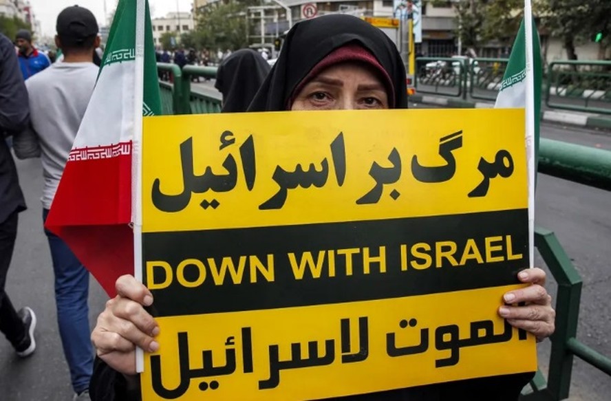 Mulher segura placa condenando Israel durante manifestação anti-israelense para mostrar solidariedade ao povo palestino em Teerã, no Irã