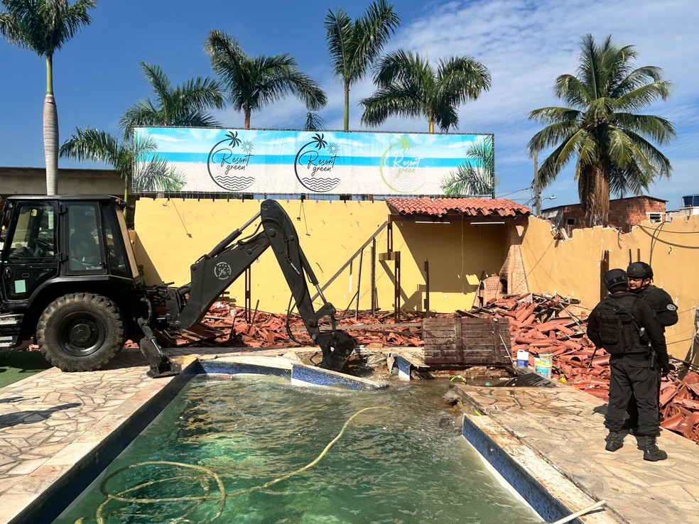 Policiais e uma das máquinas usadas na demolição do "resort" de luxo de Peixão — Foto: Gabriel de Paiva/Agência O Globo