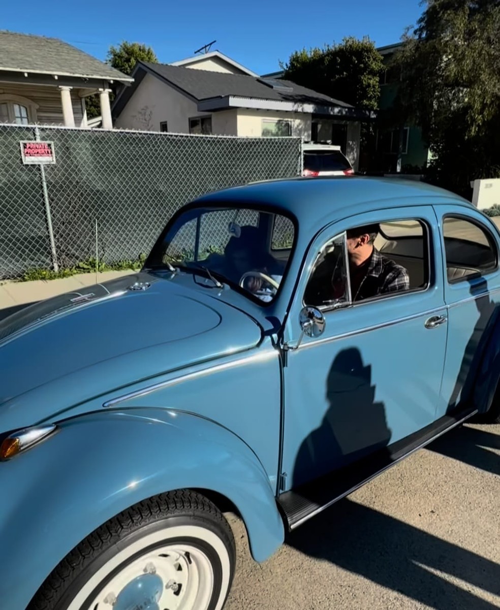 Wagner Moura em seu fusca em frente à casa onde mora em Los Angeles, nos EUA — Foto: reprodução/ X