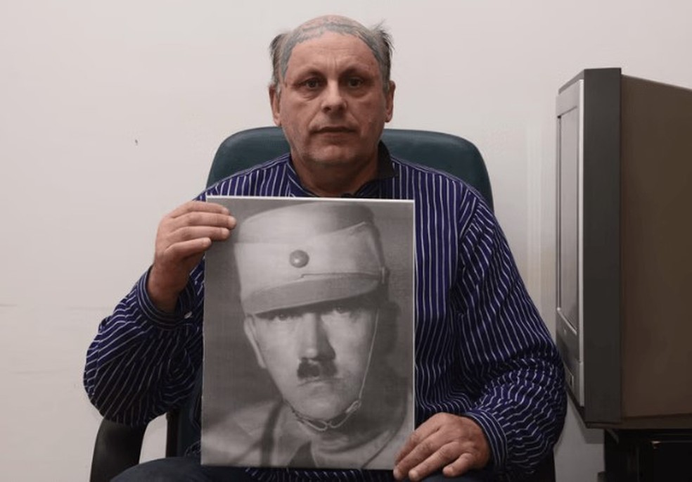Romano Lukas Hitler com foto do líder nazista, seu tio-avô — Foto: Reprodução