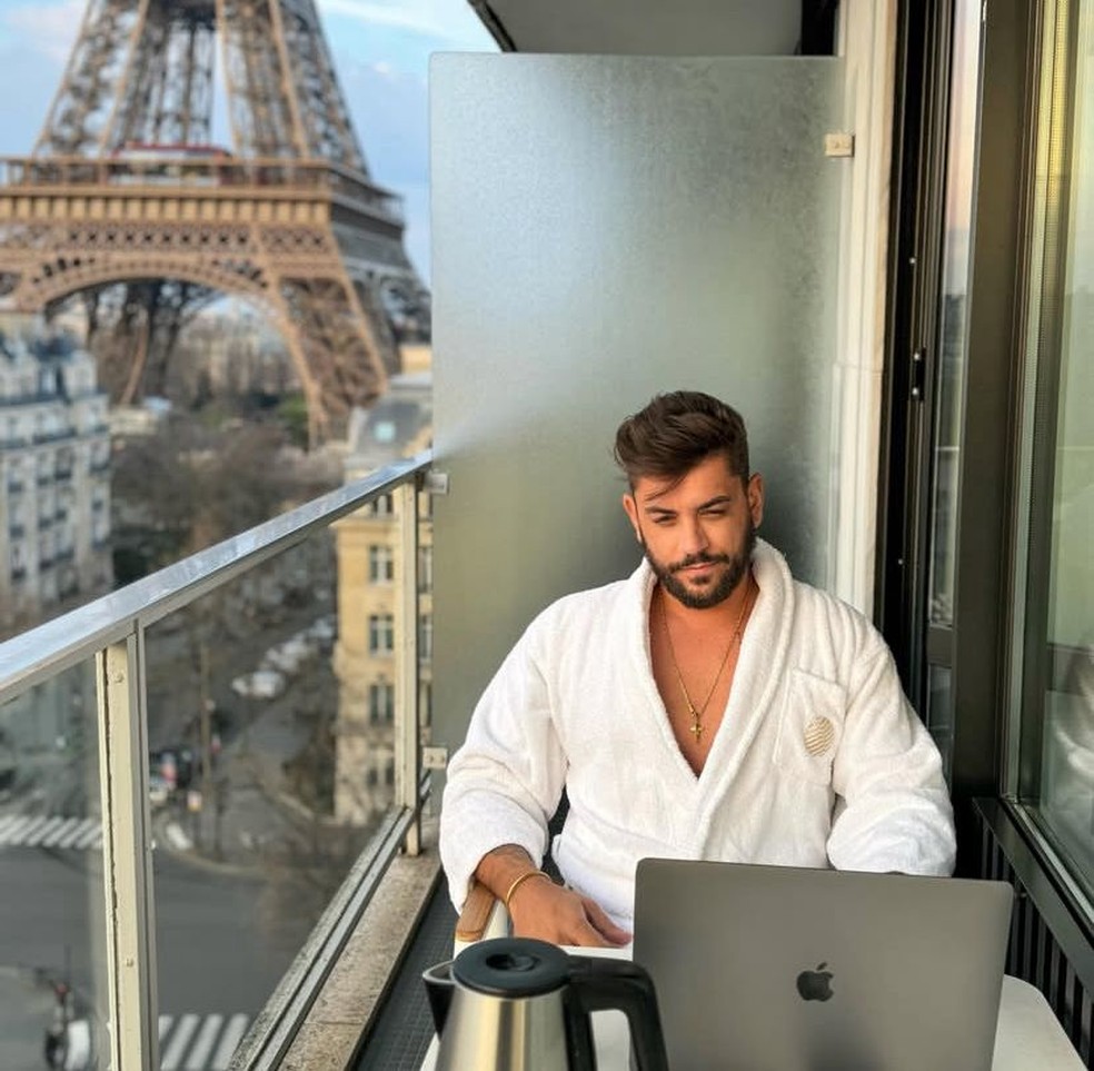 Marcos Vinícius Portugal Santos De roupão e com um notebook, com a Torre Eiffel ao fundo — Foto: Reprodução / Instagram