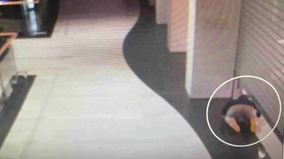 O ladrão foi pego deslizando sob a porta da loja — Foto: Polícia de Varsóvia
