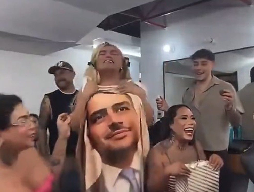 A influencer e humorista mexicana Wendy Guevara grava vídeo segurando mantar com a imagem de Harfuch — Foto: Reprodução/X