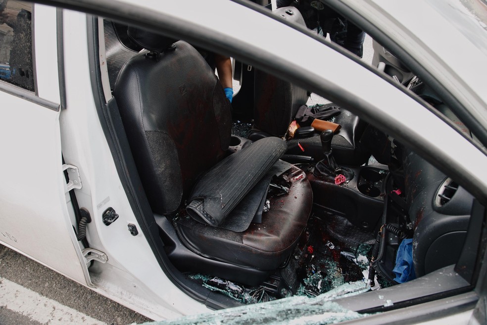 Carro da Polícia Civil atacado por bandidos na Favela do Muquiço — Foto: Marina Calderon / Agência O Globo