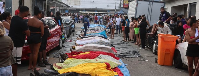 Corpos são enfileirados no chão e observados por moradores na Vila Cruzeiro, no Complexo da Penha — Foto: Fabiano Rocha / Agência O Globo