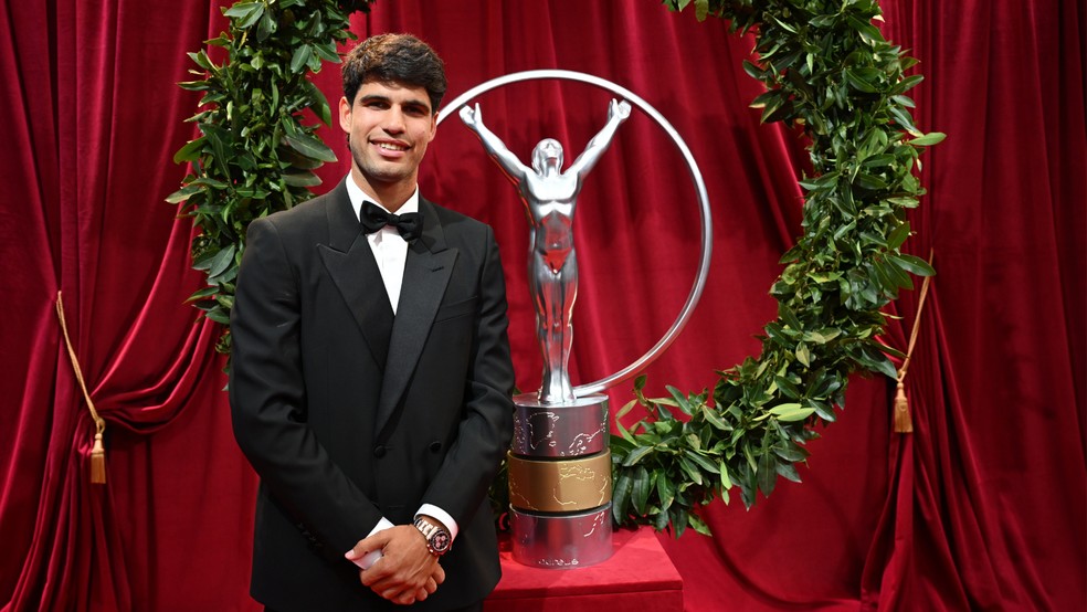 Eleito melhor atleta masculino do ano no Prêmio Laureus 2026, Carlos Alcaraz posa ao lado de versão ampliada do troféu — Foto: Carlos Alvarez/Divulgação Laureus