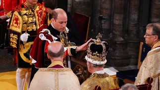O príncipe William, príncipe de Gales, toca a coroa de Santo Eduardo na cabeça de seu pai, o rei Charles III  — Foto: Yui Mok / POOL / AFP