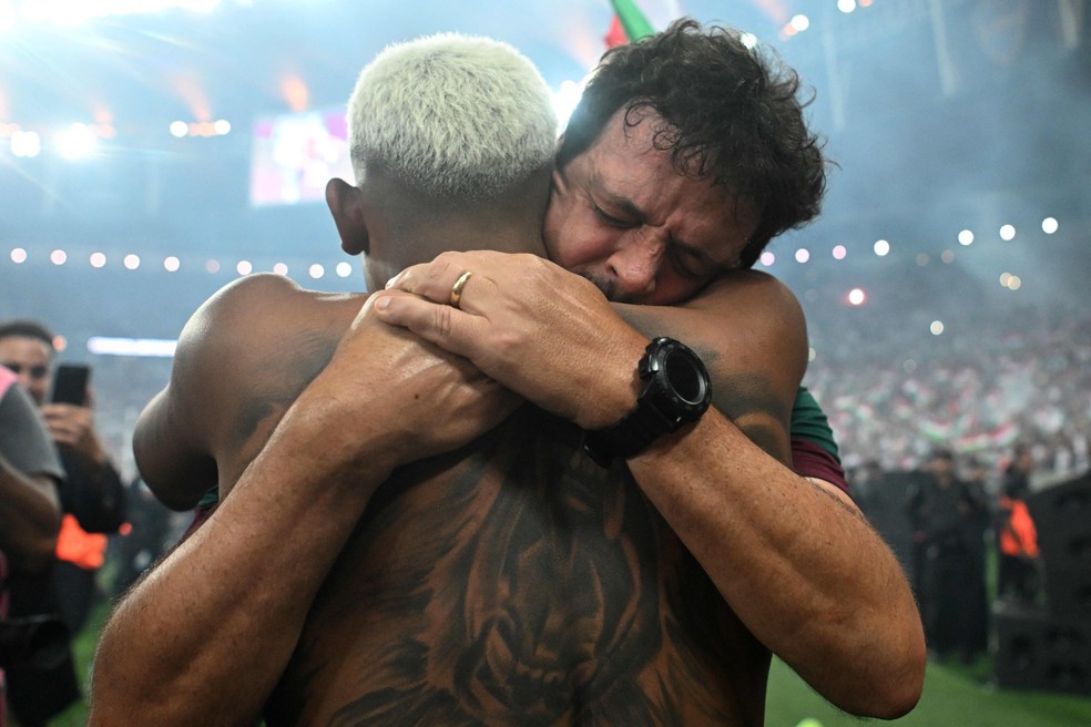 Fernando Diniz e John Kennedy se abraçam após a conquista do título da Copa Libertadores pelo Fluminense — Foto: Carl de Souza/AFP
