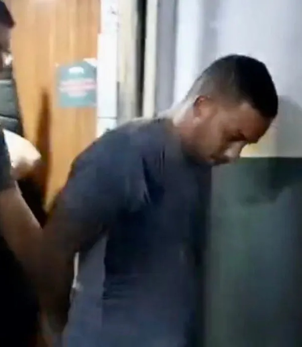 Andr&eacute; Lu&iacute;s Felipe ( com m&atilde;os para tr&aacute;s)  ao ser preso &mdash; Foto: Reprodu&ccedil;&atilde;o de tv