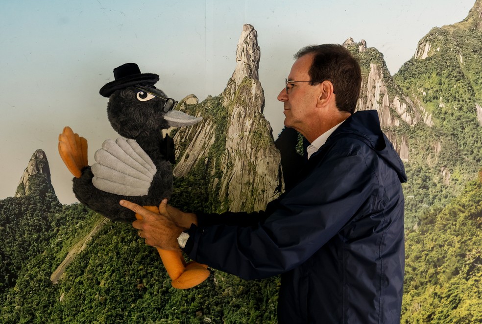 Eduardo Paes e Mister Emo: diante do Dedo de Deus encoberto, o jeito foi apelar para um painel para turistas — Foto: Gabriel de Paiva