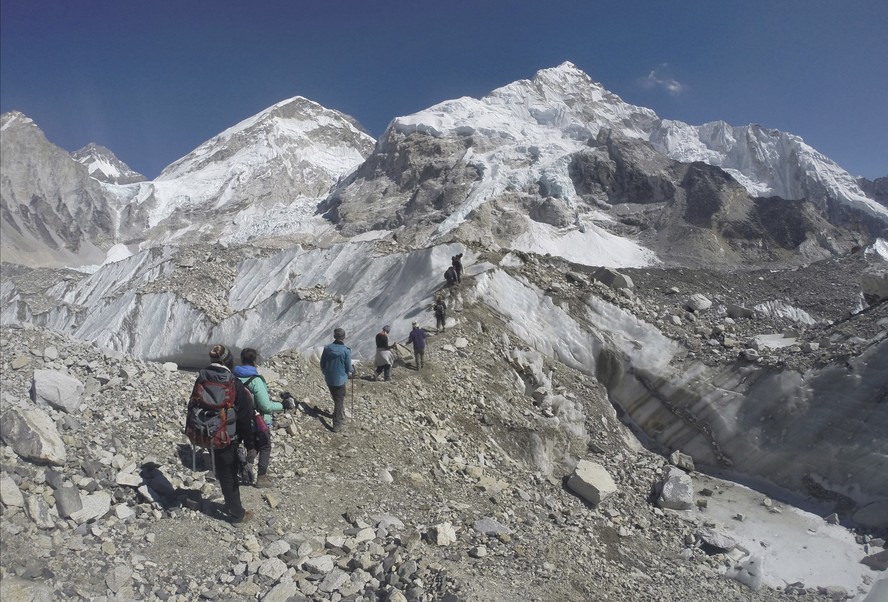 Alpinistas passam pela base do Monte Everest, no Nepal