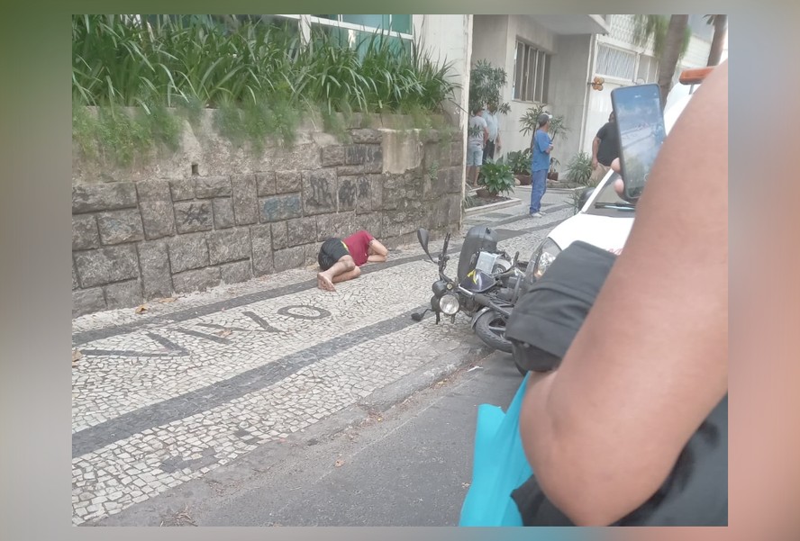 Um dos suspeitos ficou caído na calçada após ser abordado