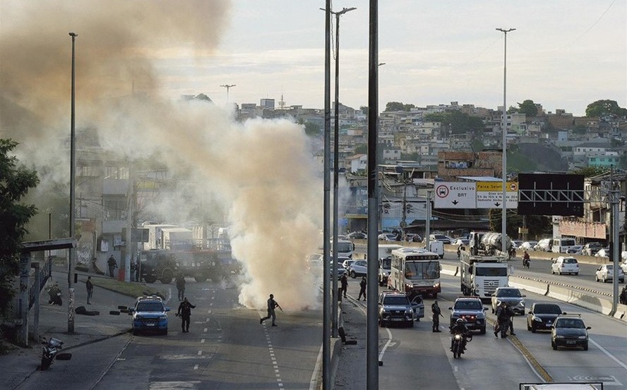 Carro incendiado pelo tráfico fecha a pista lateral da Avenida Brasil, na altura da Cidade Alta: bandidos também espalharam bloqueios pela favela para impedir avanço das forças policiais