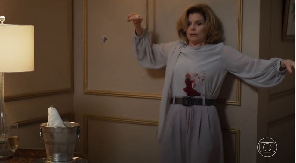 O quarto em que Odete Roitman morre em 'Vale tudo', já com uma marca de tiro na parede e uma garrafa de champanhe — Foto: Reprodução/TV Globo