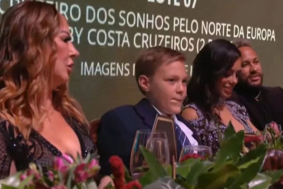 Mãe de Neymar e Bruna Biancardi sentam lado a lado em leilão — Foto: Reprodução