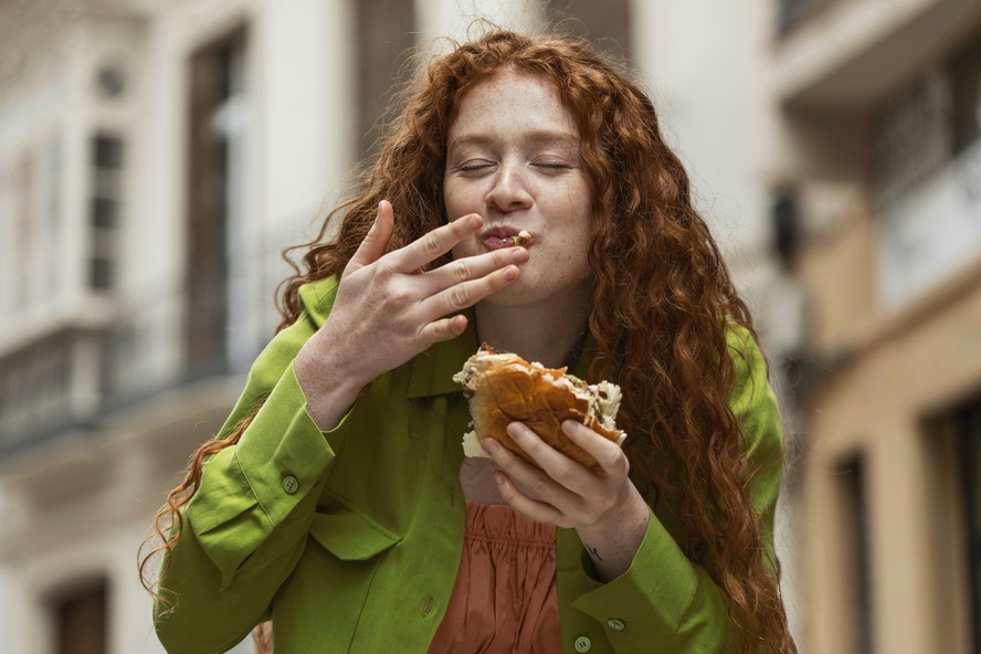 Mulher comendo hambúrguer