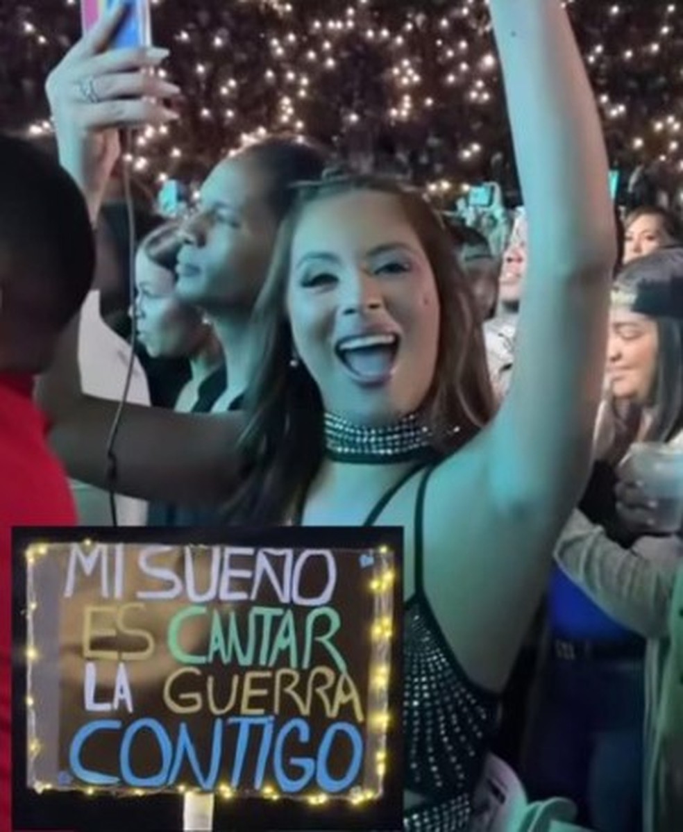 Miriam Cruz com com cartaz pedindo para cantar uma música com a banda Aventura — Foto: Reprodução/X