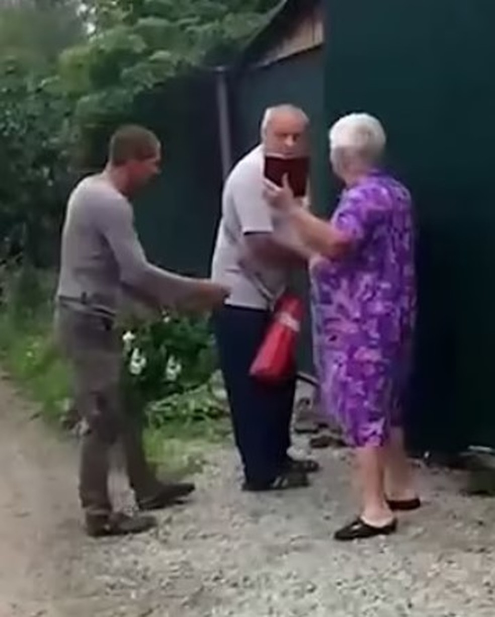 A vítima aborda o idoso antes de ser queimada em vilarejo russo — Foto: Reprodução
