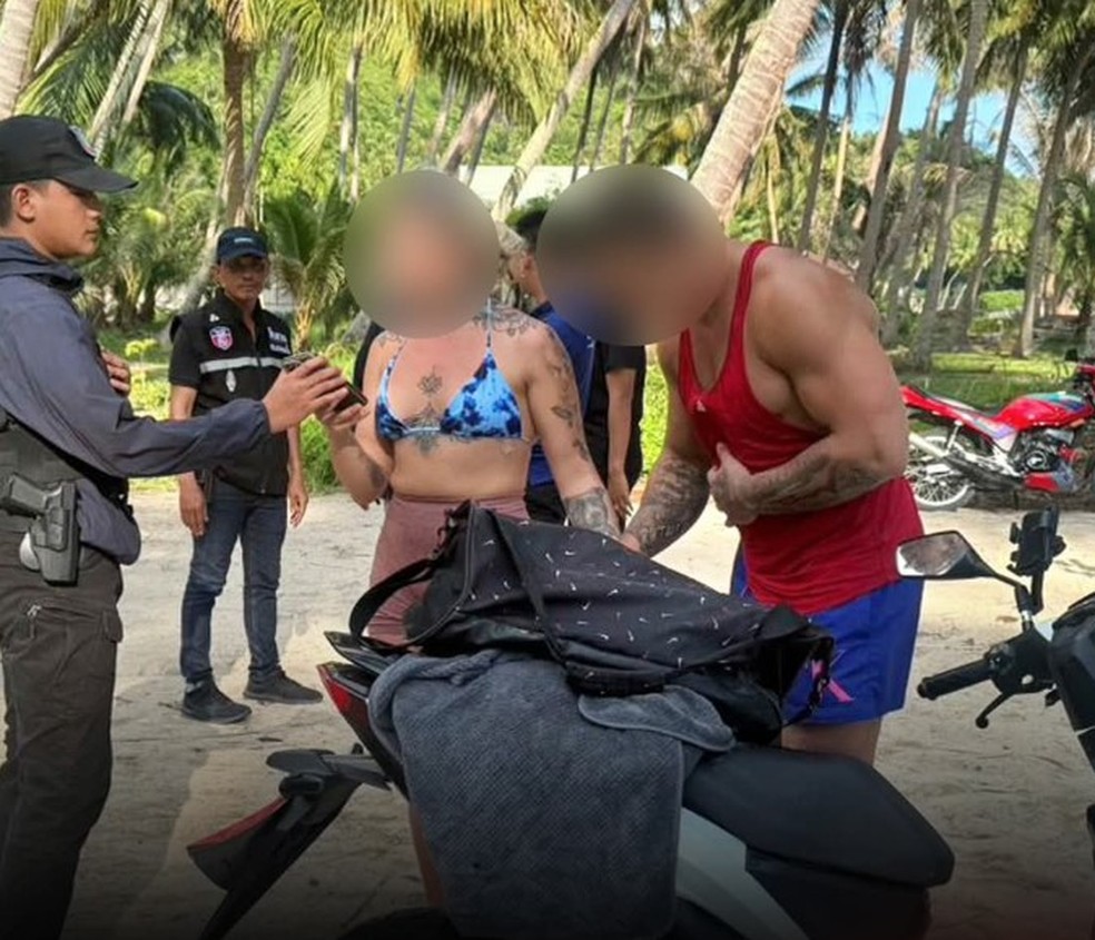 O casal de turistas se vestiu e foi levado a uma delegacia em Koh Phangan — Foto: Reprodução/X