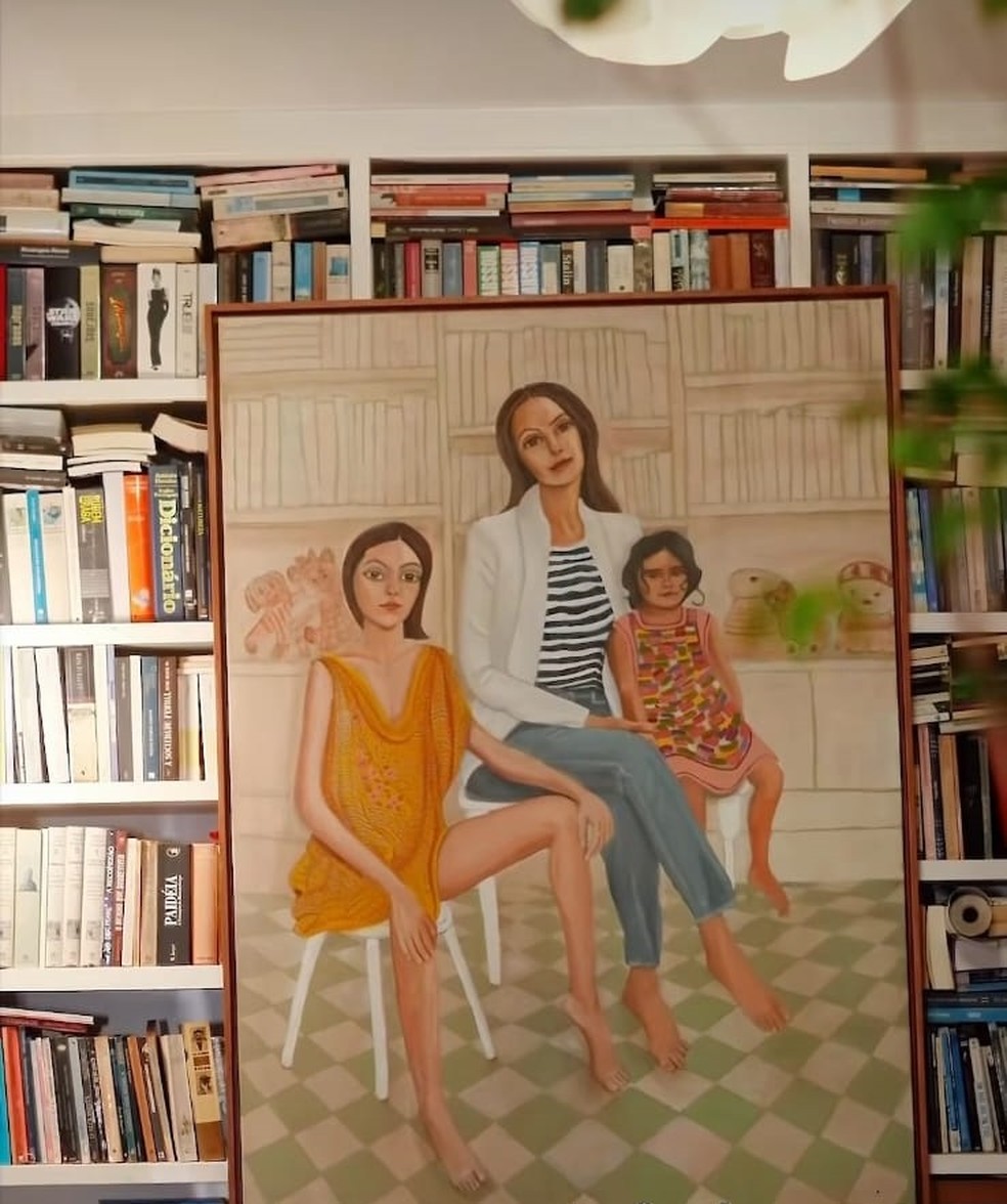 Detalhe da decoração da sala do apartamento de Carolina Ferraz em São Paulo: a atriz com as filhas em quadro de Claudia Liz  — Foto: rep/  instagram