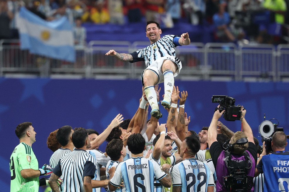 Jogadores da Argentina jogam Messi para o alto em comemoração à classificação para as quartas de final da Copa — Foto: AFP