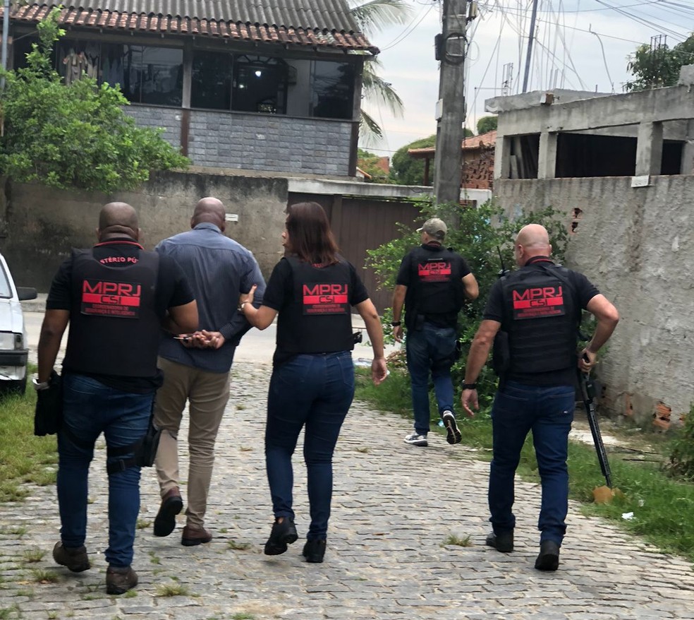 Um suspeito preso &eacute; acompanhado por agentes do MP &mdash; Foto: MPRJ/Divulga&ccedil;&atilde;o