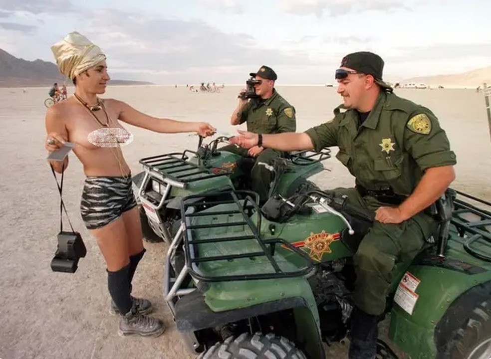 Participante fala com policiais no local onde ocorre o 'Burning Man', em Nevada (EUA) — Foto: AFP