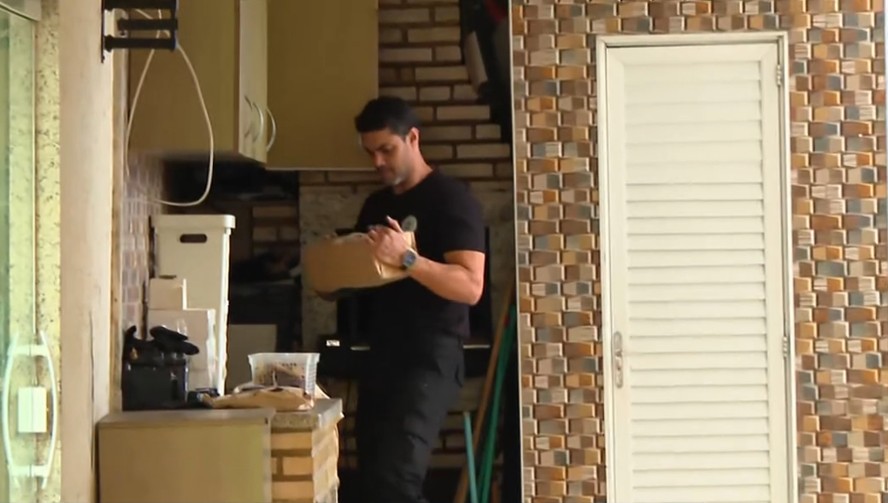 Agente da Polícia Civil cumpre mandado de busca e apreensão na casa da vereadora Gigi Castilho durante operação contra desvio de verba pública destinada a creches no Rio