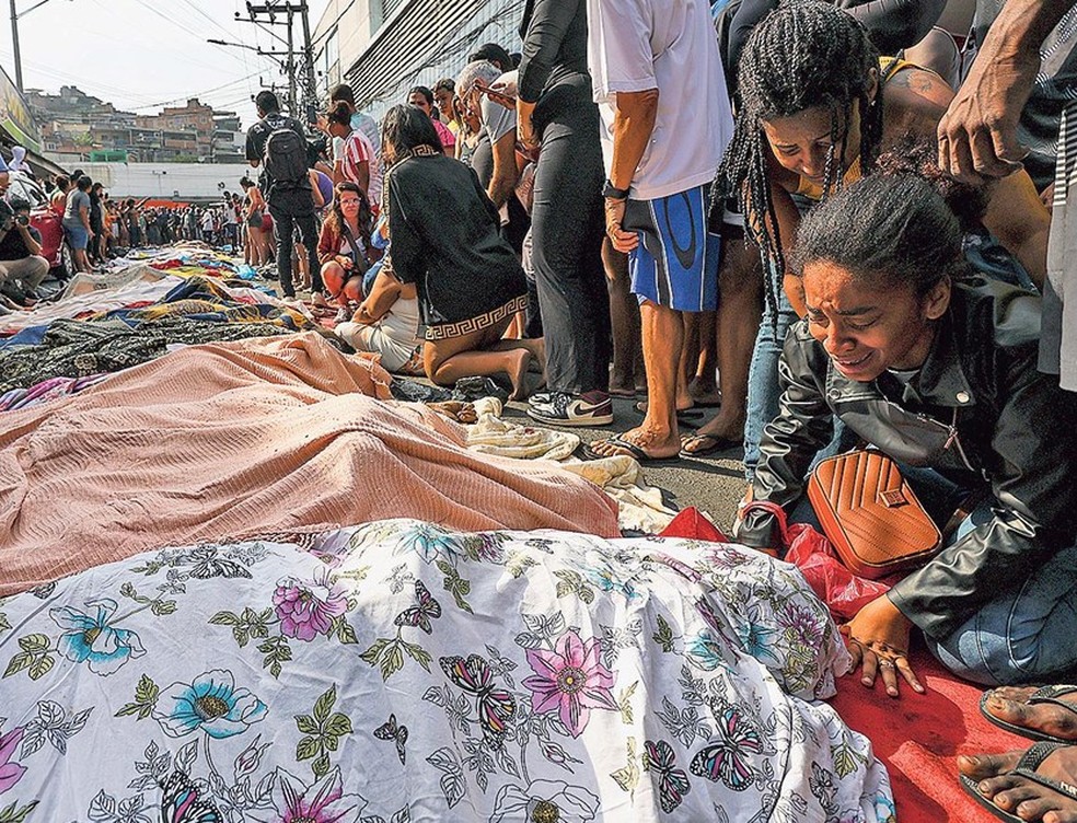 O choro delas. As mulheres eram maioria entre as pessoas que se juntaram em torno dos corpos enfileirados na rua — Foto: Gabriel de Paiva