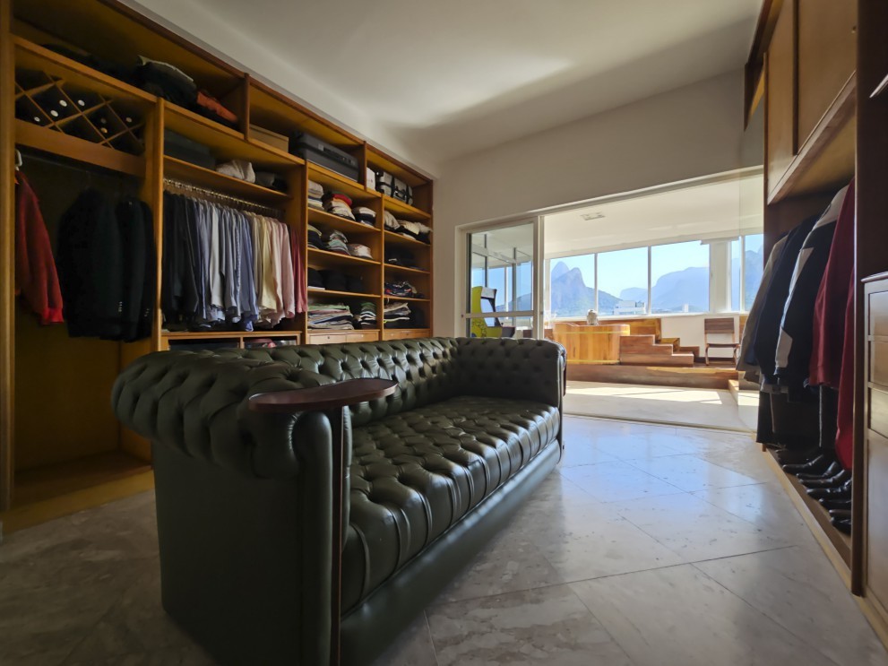 Com o conceito 'living', o closet aberto de uma das suítes tem um sofá chesterfield verde de cinco lugares  — Foto: Leo Martins/Agência O Globo