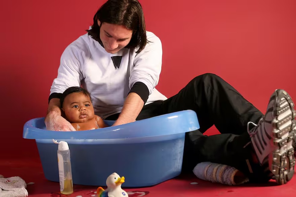 Lionel Messi banha o pequeno Lamine Yamal de apenas cinco meses para uma campanha solidária em 2007 — Foto: Joan Monfort / Sport