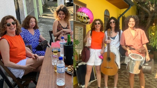 Filha de Débora Bloch comemora 30 anos ao lado da atriz e da namorada cantora na calçada de bar