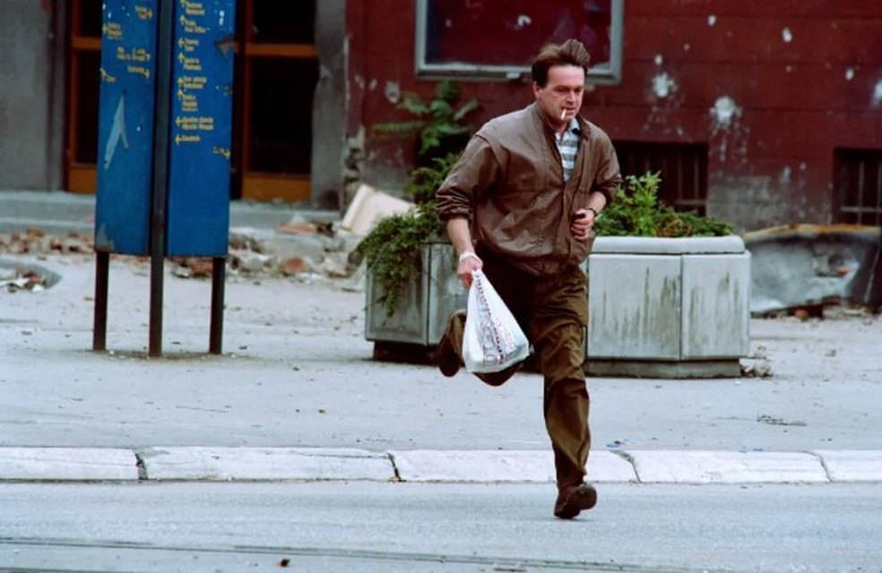 Homem corre durante tiroteio em Sarajevo, em 31 de maio de 1992 — Foto: AFP