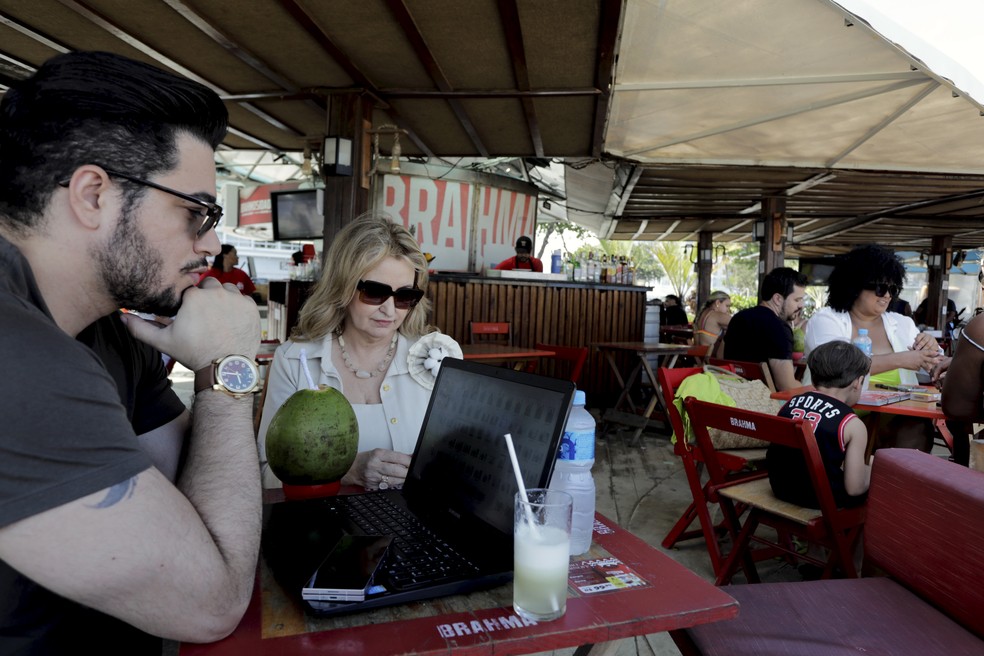 113189458-ri-rio-de-janeiro-rj-01-12-2025-meu-escritorio-e-na-praia-allisson-rodrigues-e-z Meu escritório é na praia: cariocas trocam espaços fechados pelo trabalho à beira-mar