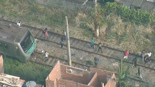 Trem descarrila perto da estação Pavuna; passageiros saltam e andam pela linha férrea