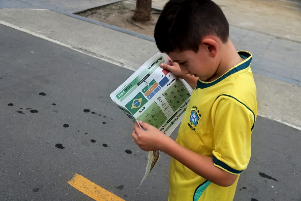 Criança, no entorno do Maracanã, com o Jogo Extra especial do confronto entre Brasil e Panamá — Foto: Fabiano Rocha