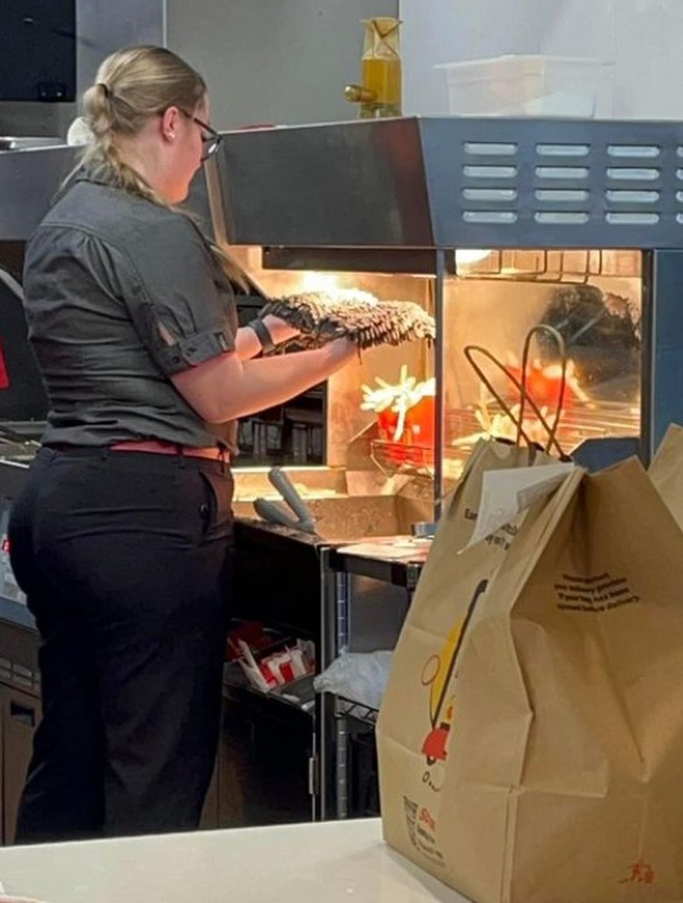 Funcionária de McDonald's na Austrália é vista secando esfregão sujo acima de batatas fritas — Foto: Reprodução/Facebook