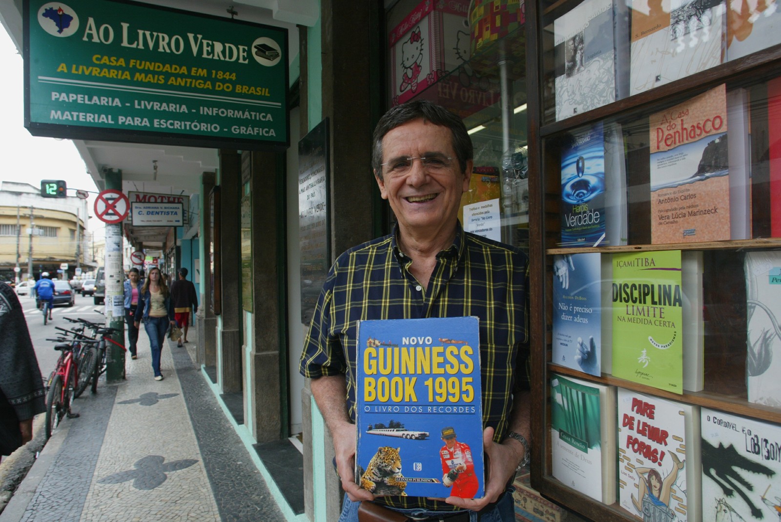 Ronaldo Sobral. dono da livraria, exibe edição de 1995 do Guinnes Book com a livraria recordista de existência mo país — Foto: Agência O Globo