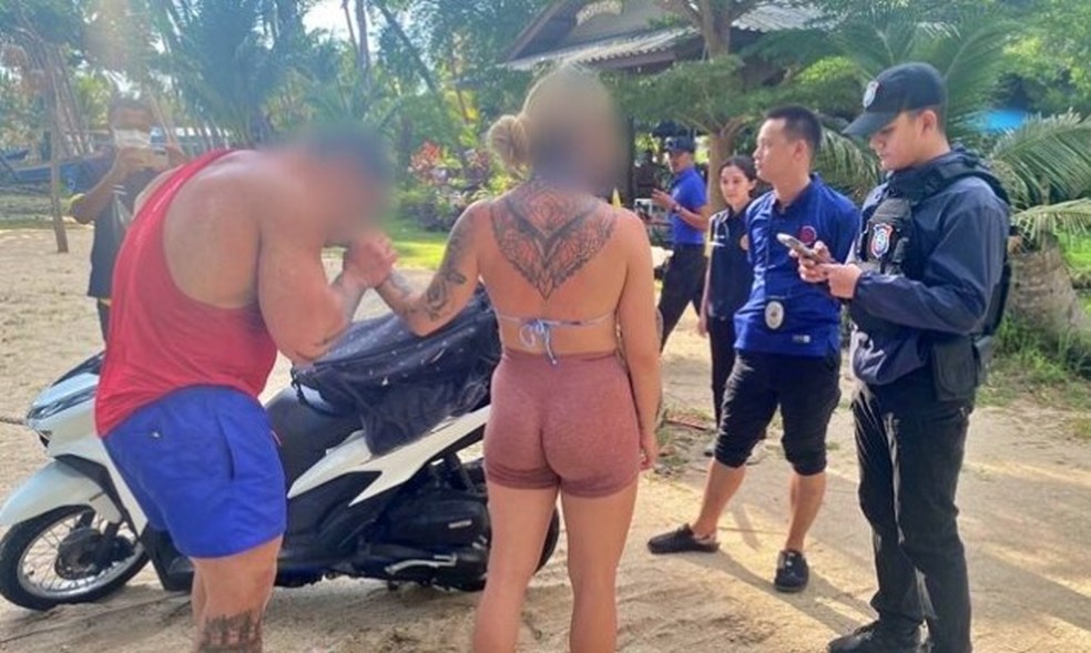 Após nudez em público, o casal de poloneses se vestiu e foi levado a uma delegacia em Koh Phangan — Foto: Reprodução