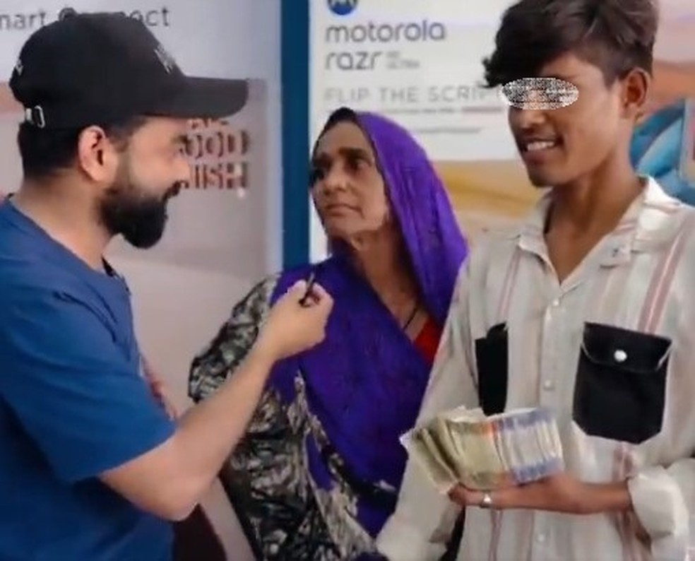 Adolescente com pilha de notas que a m&atilde;e lhe deu para comprar iPhone na &Iacute;ndia &mdash; Foto: Reprodu&ccedil;&atilde;o/X