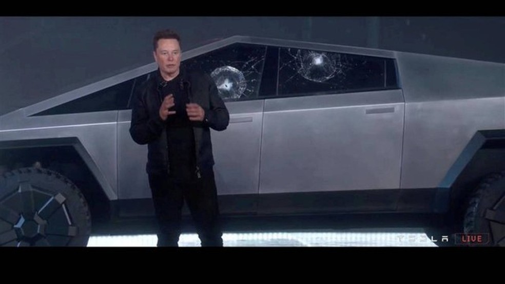 Elon Musk diante dos vidros estilhaçados do Tesla Cybertruck   — Foto:  Handout/Via Reuters
