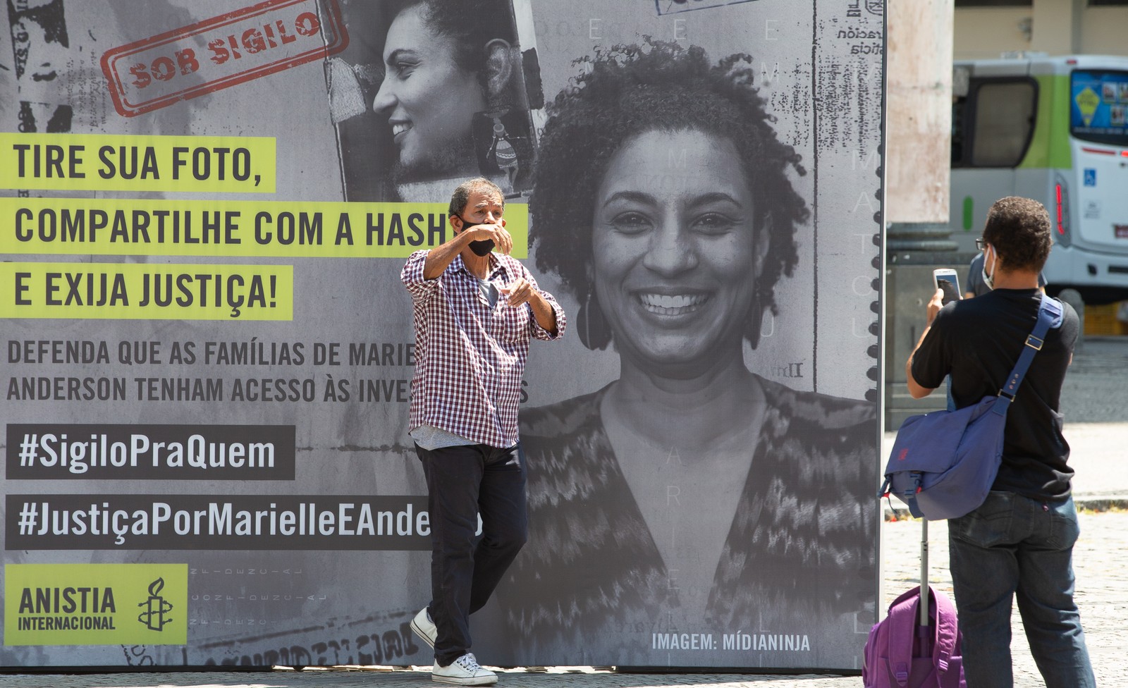 Manifestante posa em frente a cartaz para cobrar uma resposta da Justiça — Foto: Roberto Moreyra / Agência O Globo