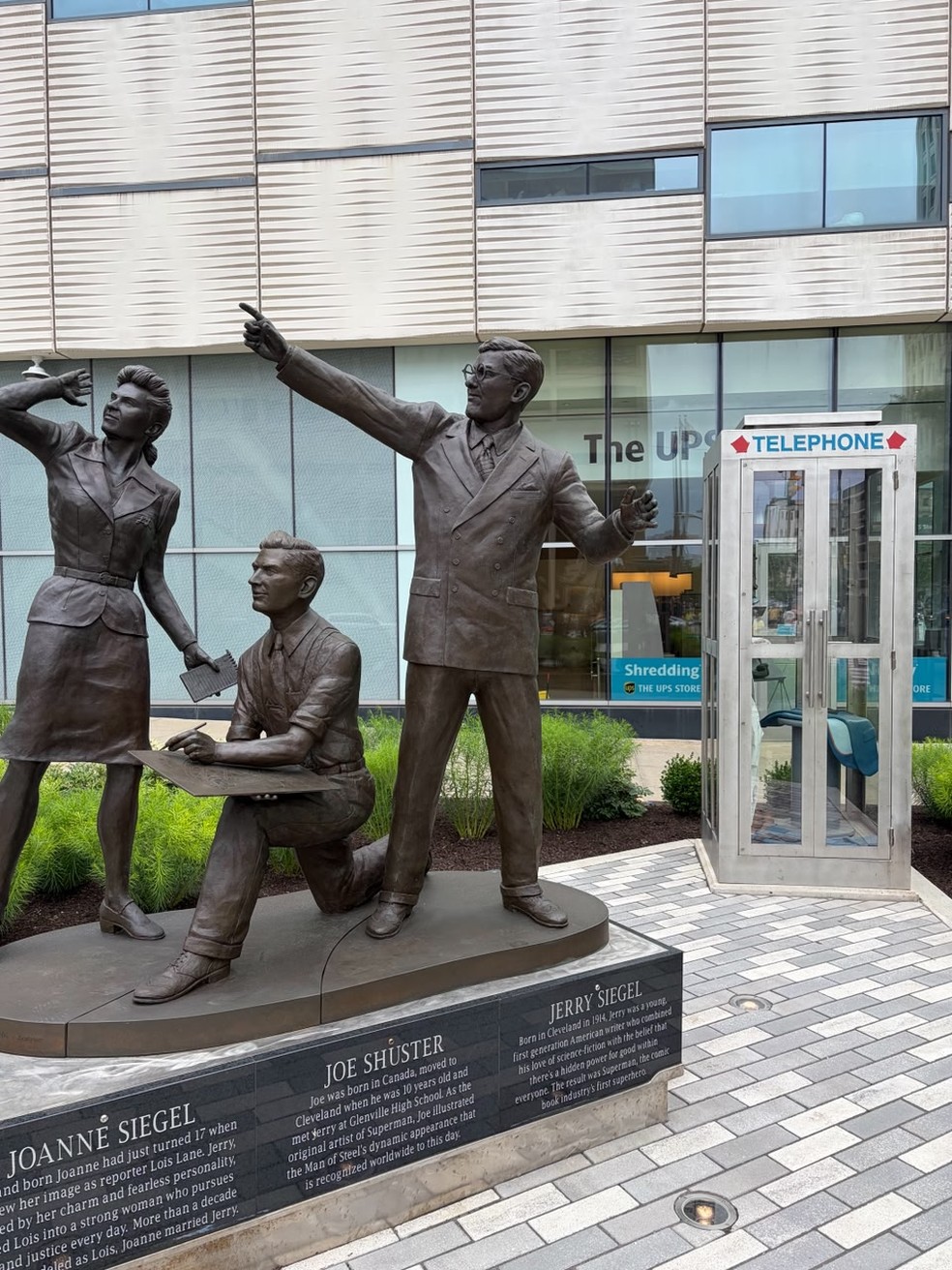 Estátuas de Jerry Siegel e Joe Shuster, criadores do Super-Homem; e de Joanne Siegel, inspiração para Lois Lane; ao fundo, a cabine telefônica — Foto: Rafael Oliveira