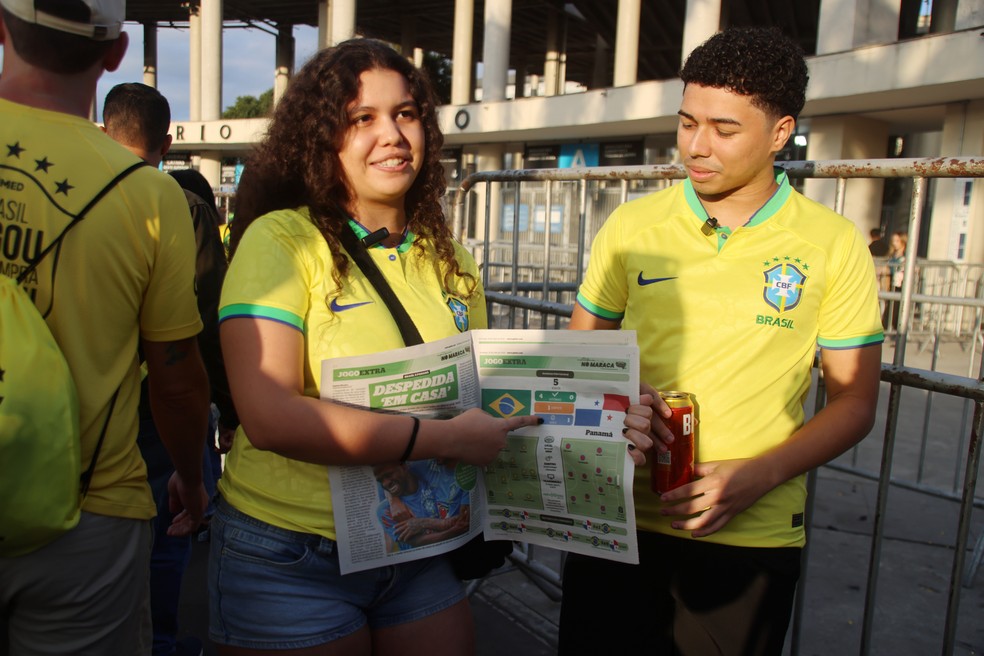  Lorena Peixoto acompanhada do namorado Guilherme Gomes; a analista aponta para a página que indica as chances de vitória do Brasil na partida — Foto: Fabiano Rocha