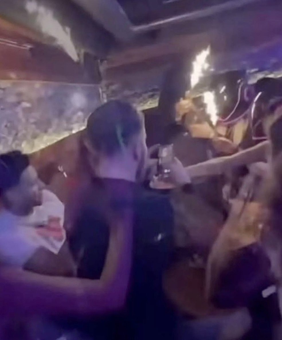 Garçonetes do Constellation com garrafas de champanhe com velas pirotécnicas — Foto: Reprodução/YouTube