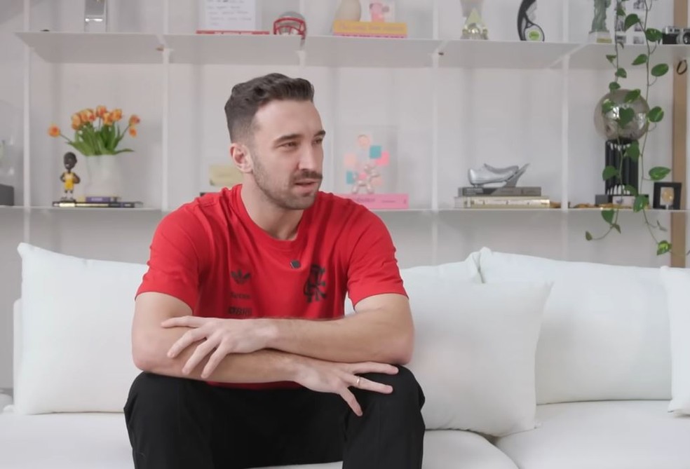 Léo Ortiz na sala de sua mansão: ao fundo a estante com bonecos e troféus — Foto: CONMEBOL Libertadores/ YouTube